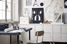 a pretty Scandinavian home office with a marble tabletop desk, a neutral chair, some storage units on casters and a black and white gallery wall