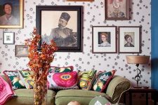 a quirky living room with a pink ceiling, printed wallpaper, a green sofa, a gallery wall, a glass coffee table and a bold rug