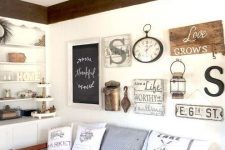a rustic gallery wall with some signs, a chalkboard sign in a frame, a clock, lamps and some monograms feels vintage