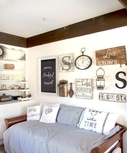 a rustic gallery wall with some signs, a chalkboard sign in a frame, a clock, lamps and some monograms feels vintage