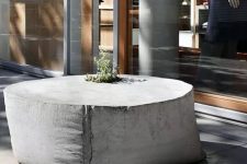a sack-shaped outdoor concrete table with a planter in the center is a unique solution that looks fresh