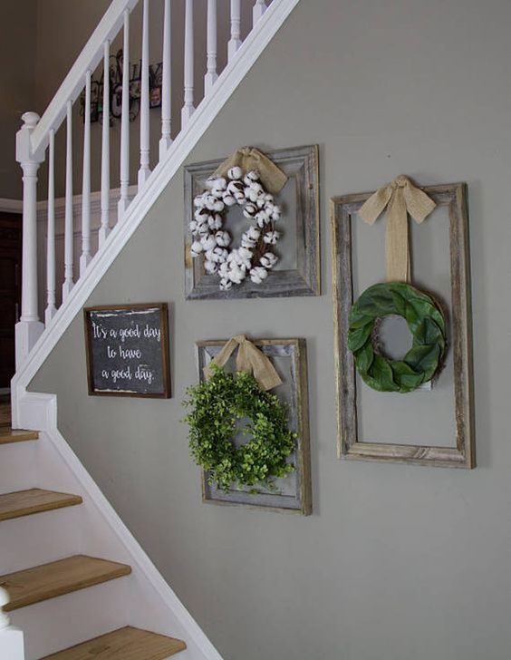 a small farmhouse gallery wall with a chalkboard sign, a wreath of faux greeneyr and green fabric, a cotton wreath is all cool