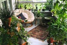 a small sunroom turned into an orangery – a couple of chairs and lots of potted greenery, the space feels like outdoors