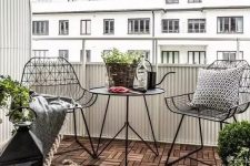 a stylish Scandinavian balcony with black metal chairs and a coffee table, candle lanterns and potted plants is a very stylish idea for a Nrodic style lover
