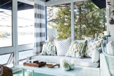 a stylish beach sunroom with an aqua floor, white wooden furniture and printed textiles