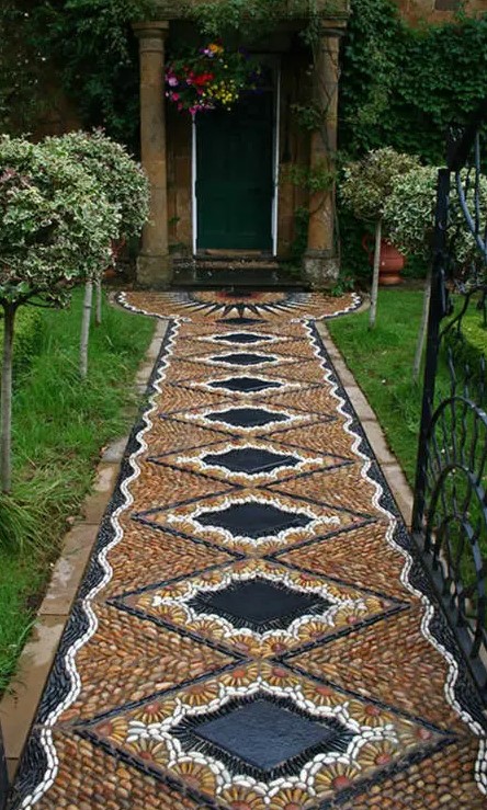 a super bold and unique pebble garden path with a geometric and floral pattern in yellow, white and black