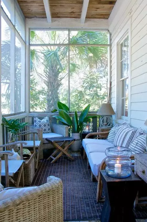 a tropical inspired small sunroom with wooden furniture, wicker chairs, potted greenery and lamps