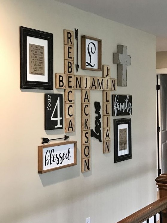 a very simple rustic gallery wall with signs in frames, names on wooden plaques, a cross and other stuff is shabby chic