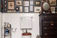 a vintage bathroom with grey walls and a dark-stained dresser, white appliances, a gallery wall and a mirror