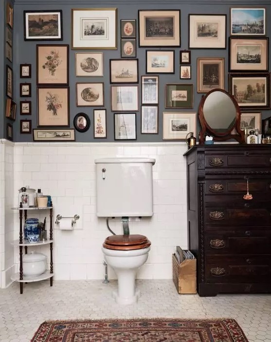 a vintage bathroom with grey walls and a dark stained dresser, white appliances, a gallery wall and a mirror