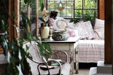 a vintage to shabby chic sunroom with elegant wooden and wicker furniture, pastel textiles, potted greenery and blooms and pastel floral textiles
