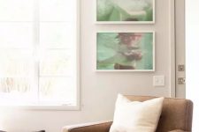 a welcoming neutral living room with light grey walls, a brown chair, a mini gallery wall with personal photos