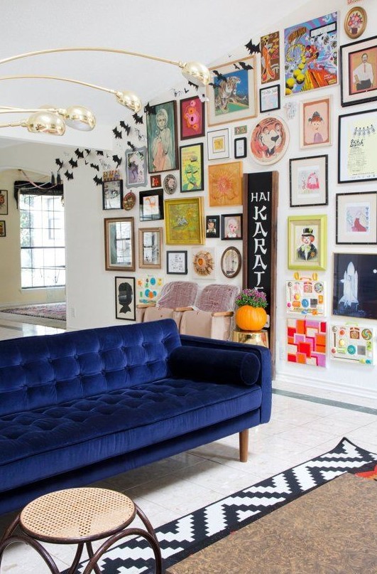 an eclectic and colorful gallery wall with bold paintings, posters, signs, prints and various elements to make it catchier