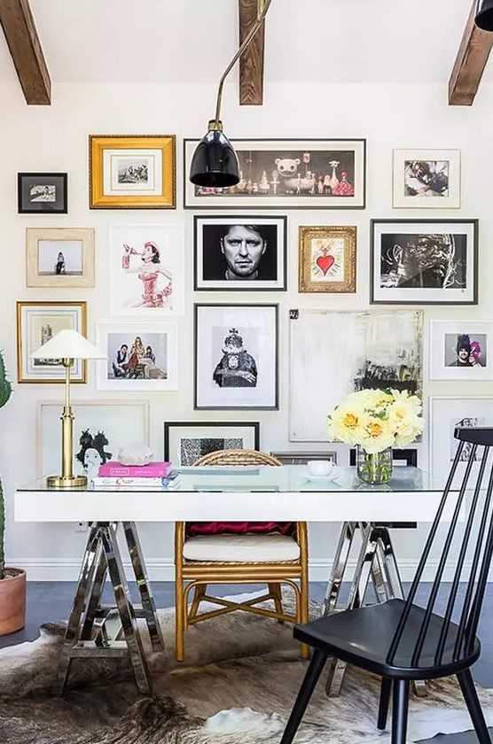 an eclectic home office with a white desk, mismatching chairs, a bright gallery wall and stained wodoen beams is amazing