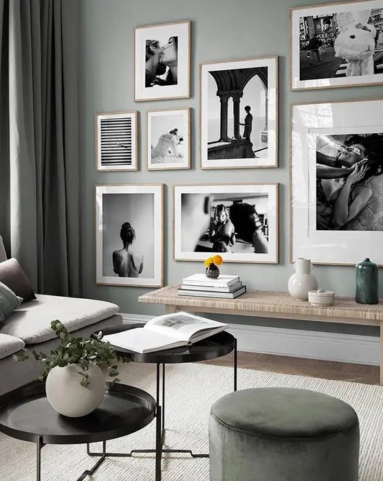 an eye catchy black and white gallery wall with a free form and light stained wooden frames for a more interesting look