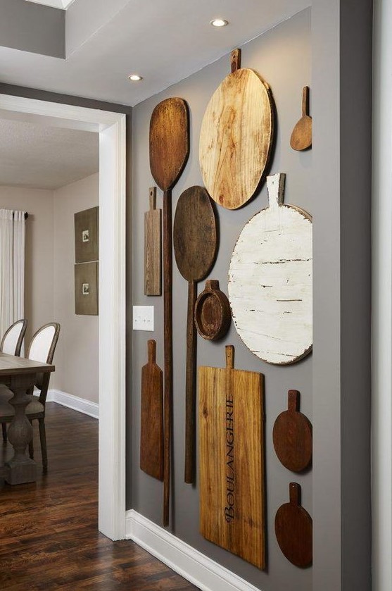 rustic kitchen wall decor with mismatching cutting boards and oars is a lovely idea for a farmhouse space