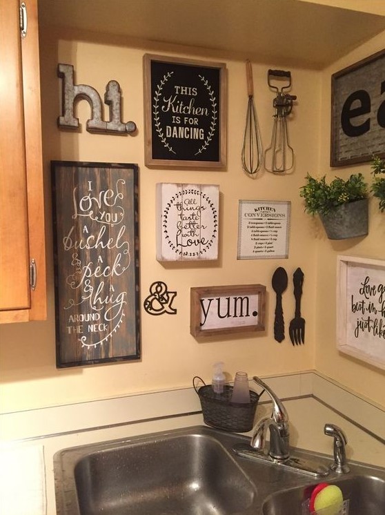 vintage and rustic kitchen wall decor with signs in frames, potted greenery, metal monograms and letters and kitchen stuff