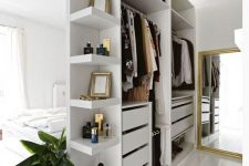 04 a small open closet in white with shelves, holders and drawers doubles as a space divider