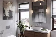 06 a modern industrial chic bathroom with concrete walls, printed tiles, a wooden vanity, exposed pipe lamps, chic appliances