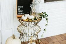 07 a stylish modern display with lots of pumpkins, geometric lanterns, black candles and a black framed sign