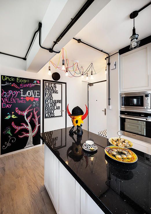 exposed black pipes paired with black fixtures and black countertops help to nail this bold and contrasting kitchen look