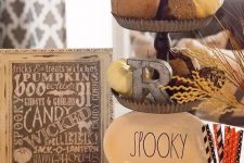 12 rustic Halloween decor with a metal tiered stand with pumpkins, a plate and a metal letter, pumpkins and a sign