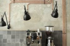 13 exposed copper pipes with black sconces give a bold and cool industrial accent to the kitchen making it wow