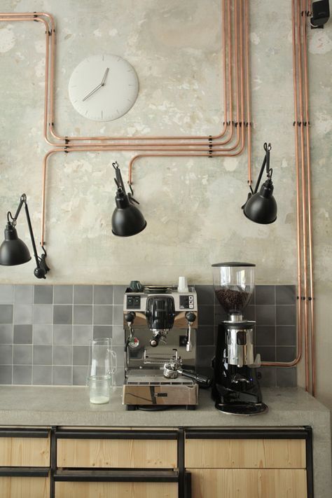 exposed copper pipes with black sconces give a bold and cool industrial accent to the kitchen making it wow