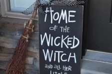18 a black and white sign, witch’s shoes, a broom and a pumpkin is a nice combo for a porch
