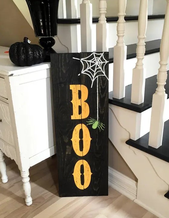a black pallet sign with BOO letters, a web and a spider is easy to make yourself giving a rustic feel to Halloween decor