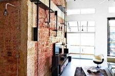 19 a brick wall and exposed black pipes make the space feel industrial and add interest to it
