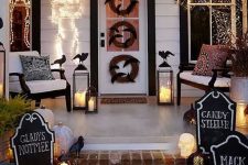 21 a bright Halloween porch with white pumpkins, candle lanterns, fake blackbirds, chalkboard signs, lights, skeletons and wreaths