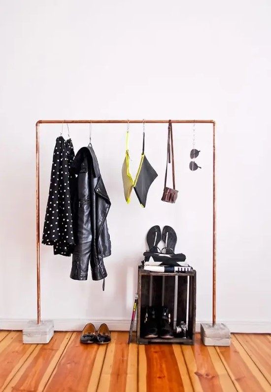 a copper pipe closet rack with a concrete base is a lovely idea for any entryway with a more modern feel