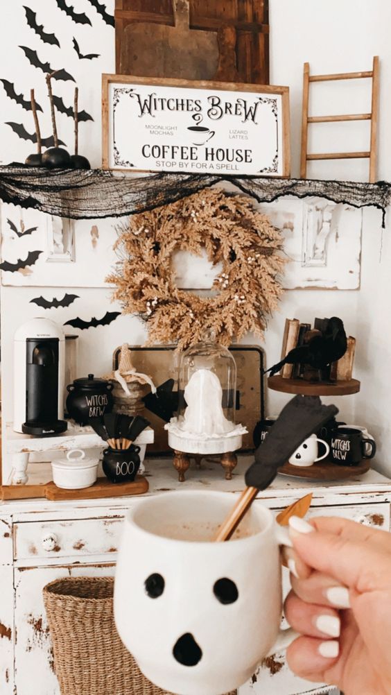 a drink station styled for Halloween with paper bats, a sign, black candied apples and blackbirds is wow