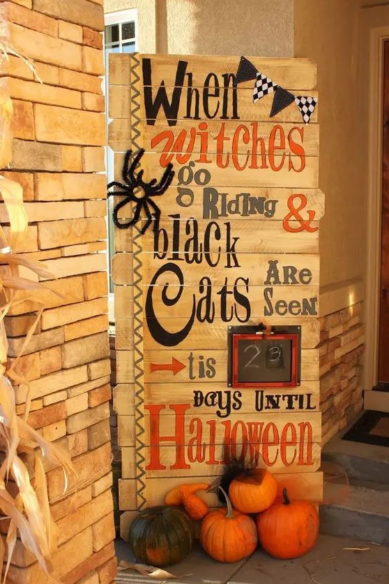 a gorgeous pallet sign with ribbons, a black and white banner, a faux spider and a frame is amazing for rustic Halloween decor