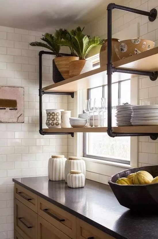 a wall mounted shelving unit of black pipes and wood is a stylish idea for adding an industrial touch to the kitchen