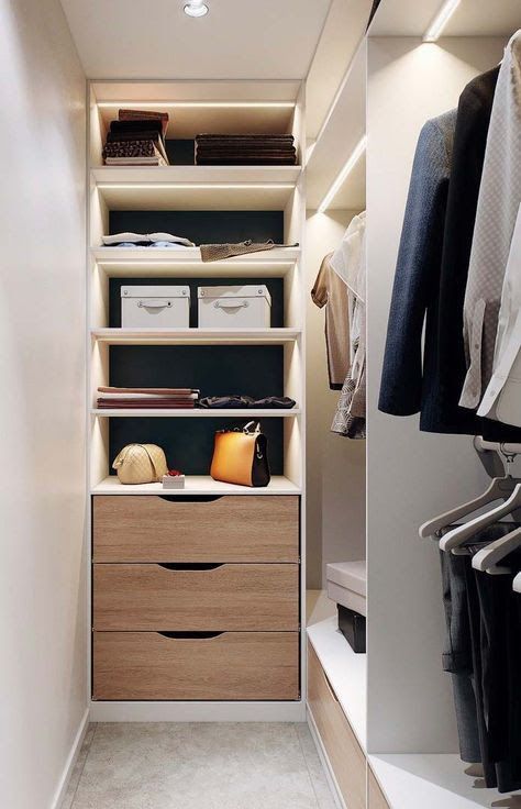 a stylish contemporary closet with built-in shelves, a built-in dresser, racks for clothes and built-in lights