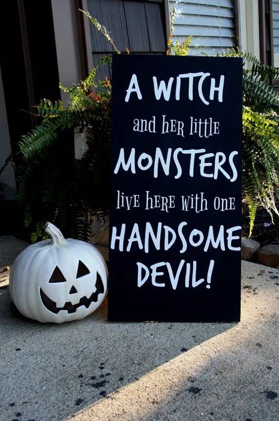 a modern black and white sign with a funny quote and a black and white pumpkin are perfect for outdoor Halloween decor