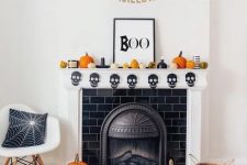 37 a modern Halloween mantel with a skull banner, pumpkins, a sign and a banner is a lovely idea for the holiday