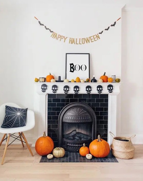 a modern Halloween mantel with a skull banner, pumpkins, a sign and a banner is a lovely idea for the holiday