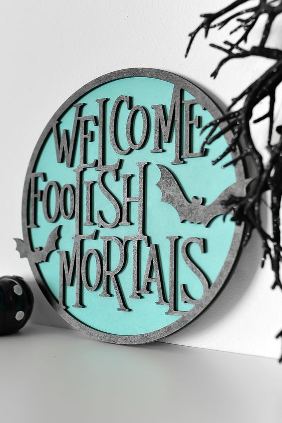 a modern round sign in grey and turquoise, with bats is a great and chic idea for Halloween