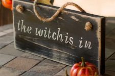 46 a wooden sign paired with some faux pumpkins for chic and stylish Halloween decor