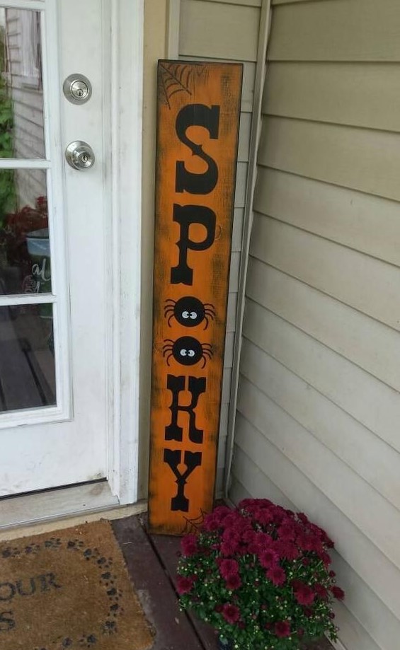 an oversized spooky sign made of distressed wood is right what you need for a front porch