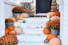 52 elegant farmhouse porch decor with natural pumpkins, bold fall blooms, a sign and touches of black and white for a Halloween feel