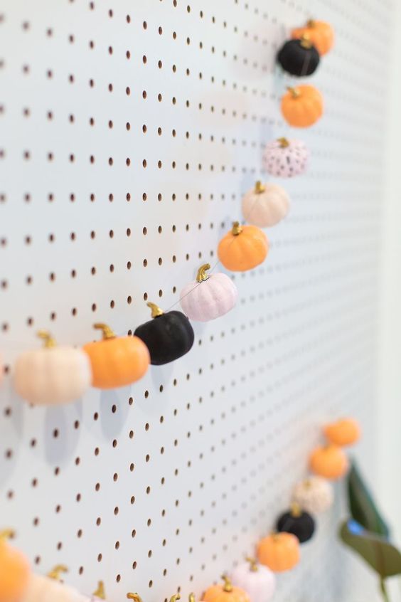 a Halloween faux pumpkin garland in blush, orange and black, with gilded stems is a great decoration for fall and Halloween