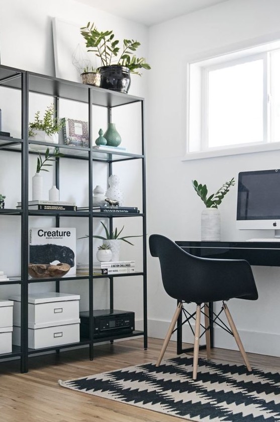 a Nordic black and white home office with a printed rug, a black shelving unit and desk plus a chair