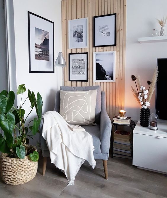 a Scandi reading nook with a grey chair with neutral textiles, a black and white gallery wall in the corner to add eye-catchiness