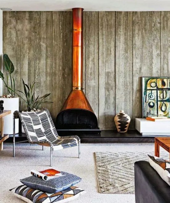 a beautiful living room with an accent wall clad with reclaimed wood, a rust-colored Malm fireplace, a boho chair and some elegant seating furniture