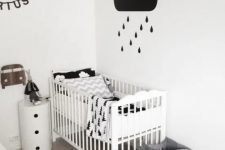 a black and white Nordic kid’s room with a white bed and a nightstand, fabric baskets for storage, black and white decor and bedding