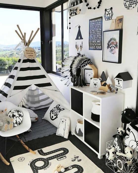 a bold adventuruous nursery with a striped teepee, a dresser, a gallery wall and a play rug on the floor